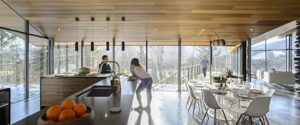 People relaxing in the kitchen of The Stowe Glass House in Stowe Vermont